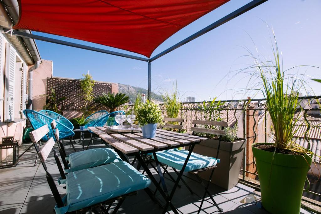 um pátio com uma mesa e cadeiras numa varanda em 2 pièces avec grande terrasse - Centre de Toulon em Toulon