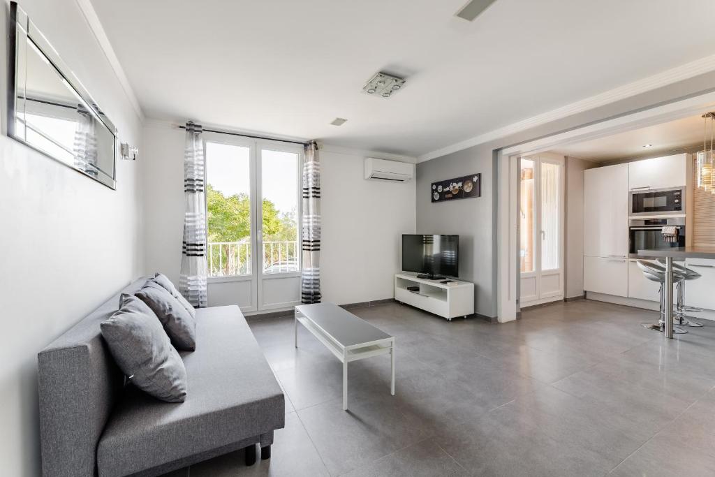 un salon avec un canapé et une télévision dans l'établissement Le Bosquet 1 par Dodo-a-Cassis, à Cassis