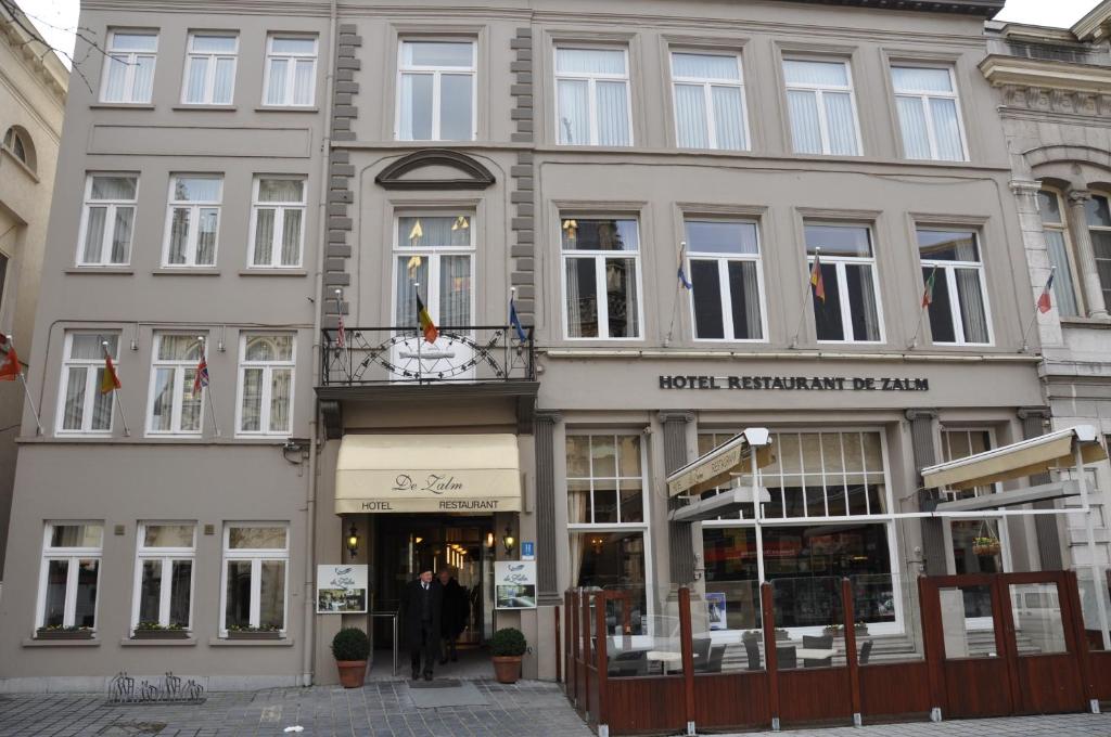 un gran edificio con gente caminando delante de él en Hotel De Zalm en Oudenaarde