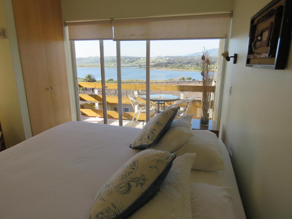 a bedroom with a bed with a view of a balcony at Riomar Apart Hotel in Concón