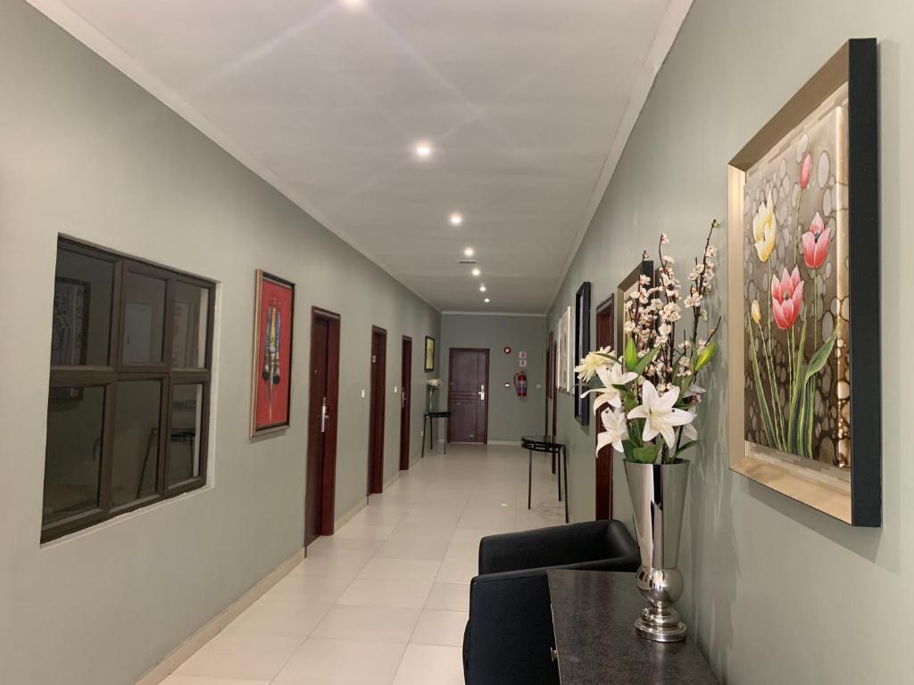 a hallway with a vase of flowers on a table at Bannerloft Guest house in Gaborone