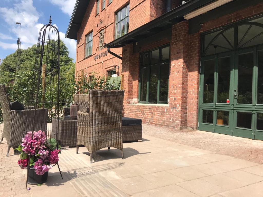 a building with chairs and flowers in front of it at Tree Top Hill - The Old Station House - Båstad Holiday Apartments in Båstad