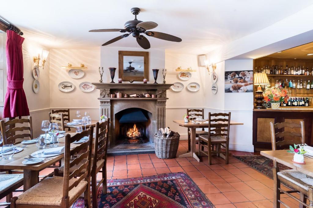uma sala de jantar com lareira e mesas e cadeiras em The Acorn Inn em Evershot