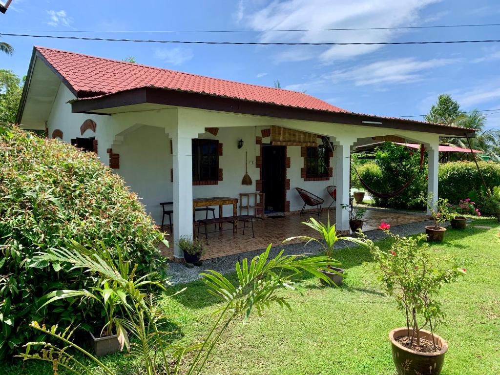 uma pequena casa com um telhado vermelho em Lovely Garden Villas em Pantai Cenang