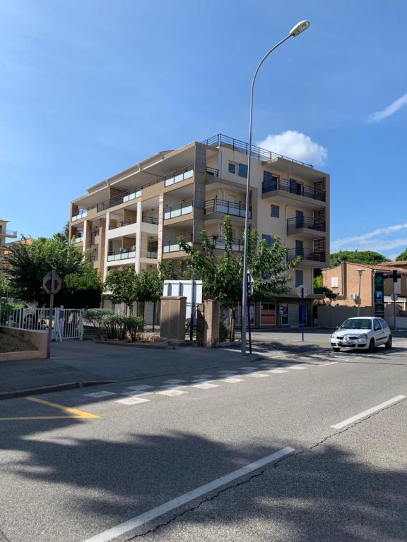 a white car parked in front of a building at Appartement 4 chambres LE BAIA in Sainte-Maxime