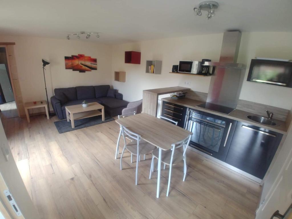 eine Küche und ein Wohnzimmer mit einem Tisch und einem Sofa in der Unterkunft Casabann in Langrune-sur-Mer
