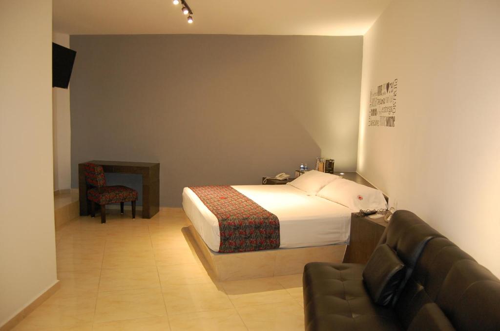 - une chambre avec un lit, une chaise et un canapé dans l'établissement Hotel Dulce Boca, à Veracruz