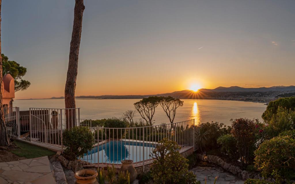 una villa con vistas al océano al atardecer en Château des Anglais - Five Stars Holiday House, en Niza