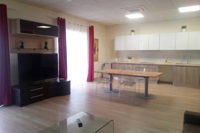 ローマにあるVetere 101 Apartmentの広いリビングルーム(テーブル付)、キッチンが備わります。
