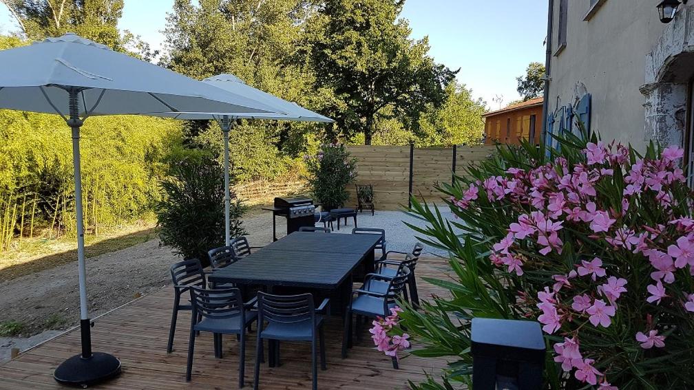 una mesa y sillas con sombrilla y flores en les Crozes Petit, en Revel