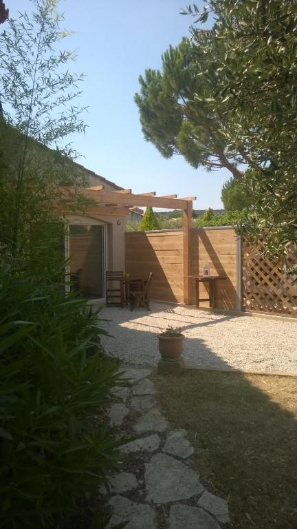 une arrière-cour avec une table de pique-nique et une clôture dans l'établissement Studio Indépendant avec parking fermé et sécurisé, à Lédenon