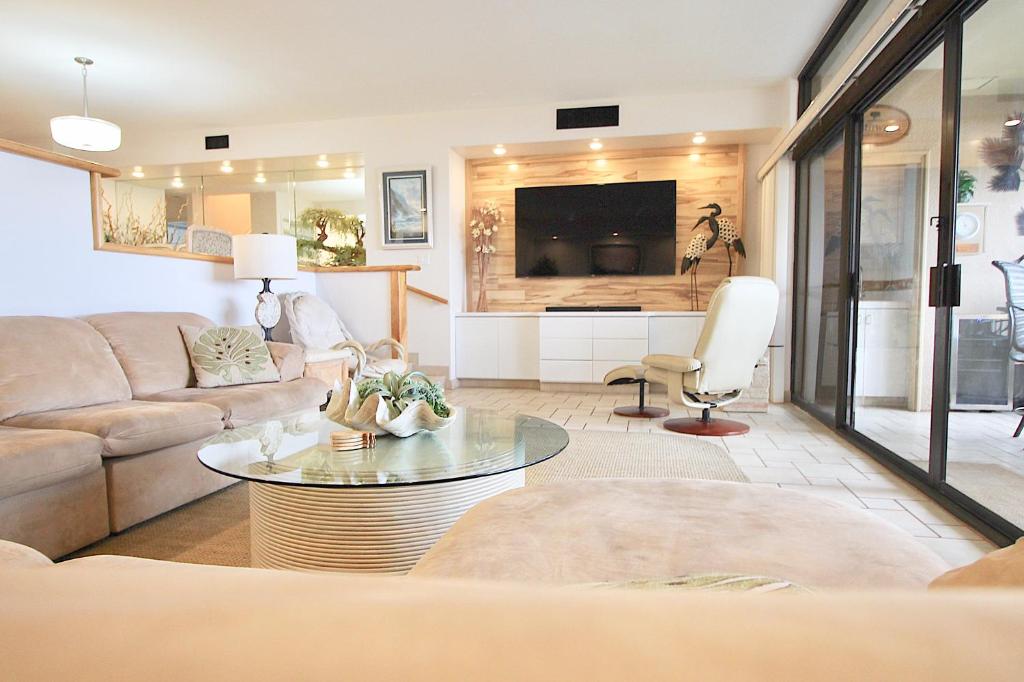 a living room with a couch and a tv at Kaanapali Royal J303 in Lahaina