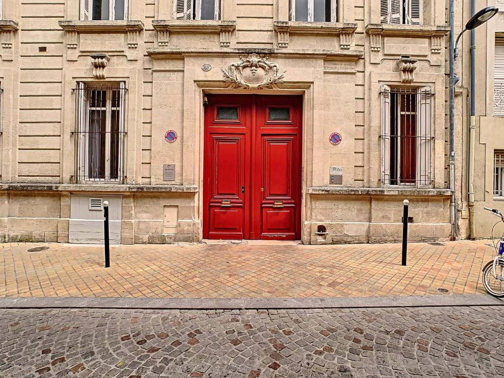 a red door on the side of a building at La Maison de Sebea in Bordeaux