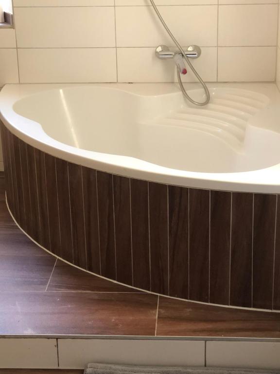 eine Badewanne im Bad mit Holzboden in der Unterkunft Hotel Einstein in Bad Krozingen