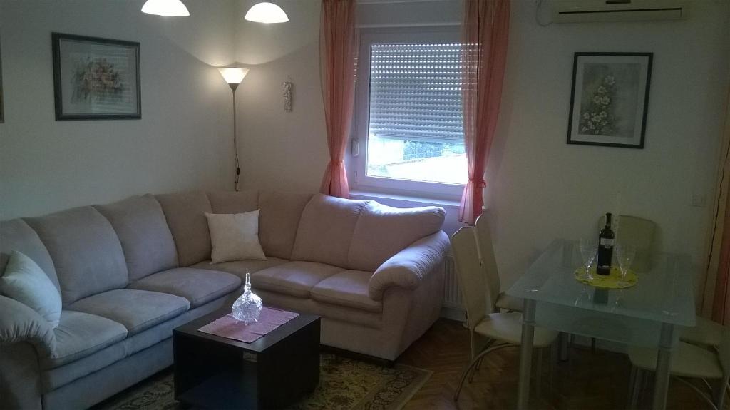 ein Wohnzimmer mit einem Sofa und einem Tisch in der Unterkunft Apartman Mario in Osijek