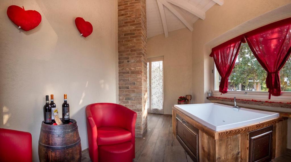 baño con bañera, silla roja y corazones en la pared en Villa Laura, en Castellinaldo
