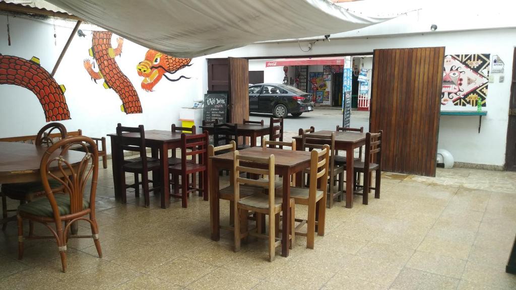 a restaurant with wooden tables and chairs in front of a building at Tatos House in Huanchaco