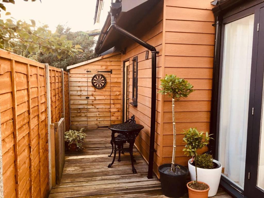 a small patio with a table on a wooden deck at Oak Tree Studio in Marlow