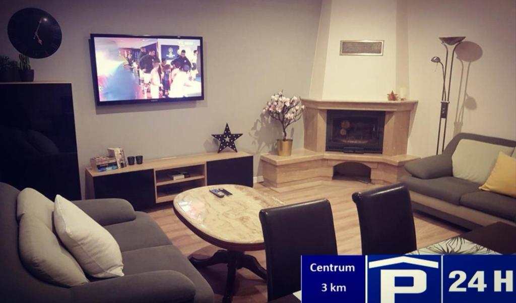 uma sala de estar com um sofá, uma mesa e uma televisão em Red Rose Apartament -Parking -Taras- Faktura VAT em Kielce