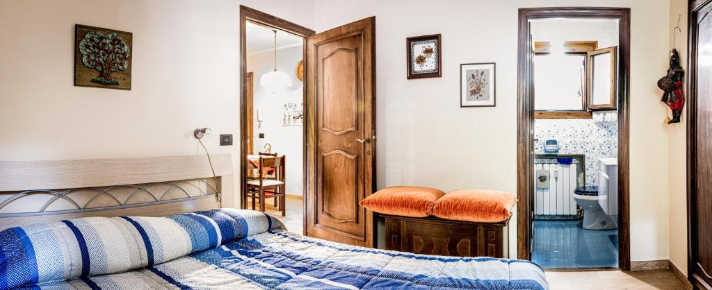 a bedroom with a bed with a blue and white blanket at Appartamento Valeria in Terminillo