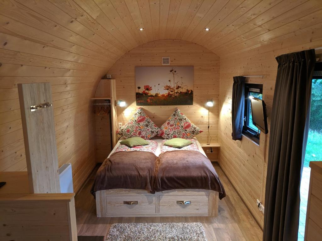 ein kleines Schlafzimmer mit einem Bett in einem kleinen Zimmer in der Unterkunft Rhön Lodge in Poppenhausen