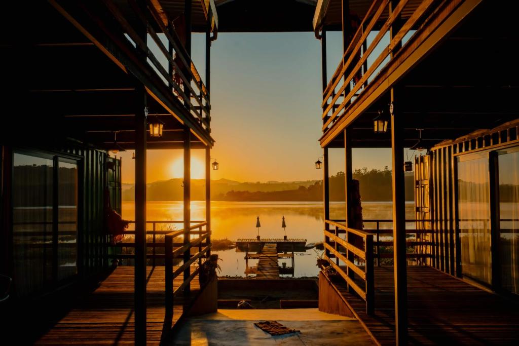 un muelle con un barco en el agua al atardecer en Villa Container Lodge en Capitólio