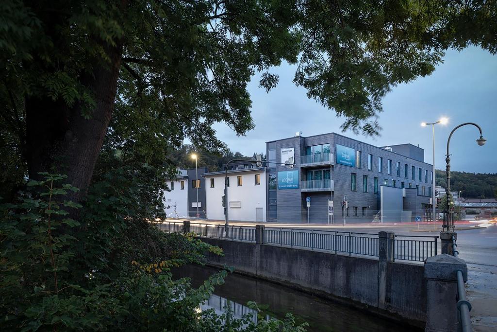 a building on a bridge next to a river at ECOME Hotel in Heidenheim an der Brenz