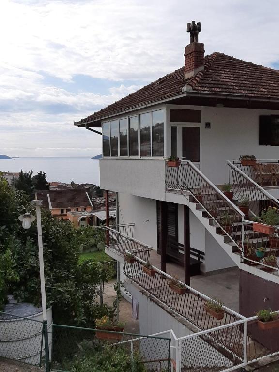 a white house with balconies and a view of the ocean at Maja Apartman in Igalo
