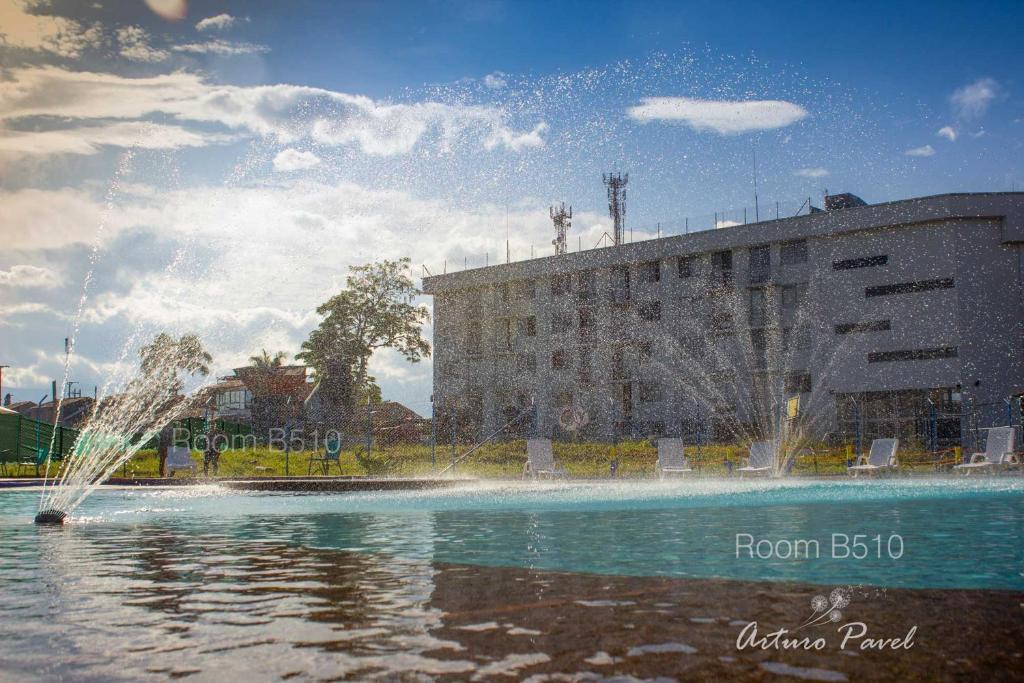 una fuente en el agua frente a un edificio en Apartamento cerca al Parque del Café, Eje Cafetero, en Montenegro