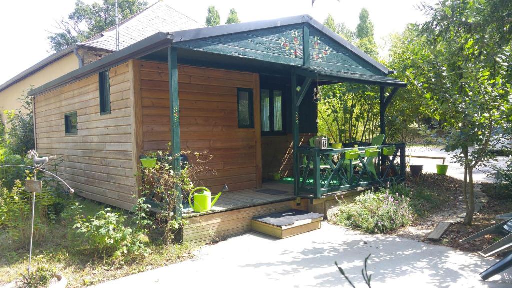 Cabaña de madera con porche con techo en Chalet Du Bas-Mée, en Le Mée