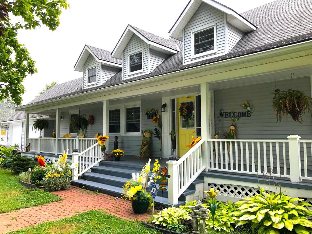 a white house with a porch with flowers on it at Yellow Door Bed and Breakfast in Crystal Beach