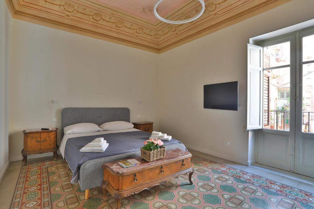 a bedroom with a bed with a table and a tv at Storie di Palermo in Palermo