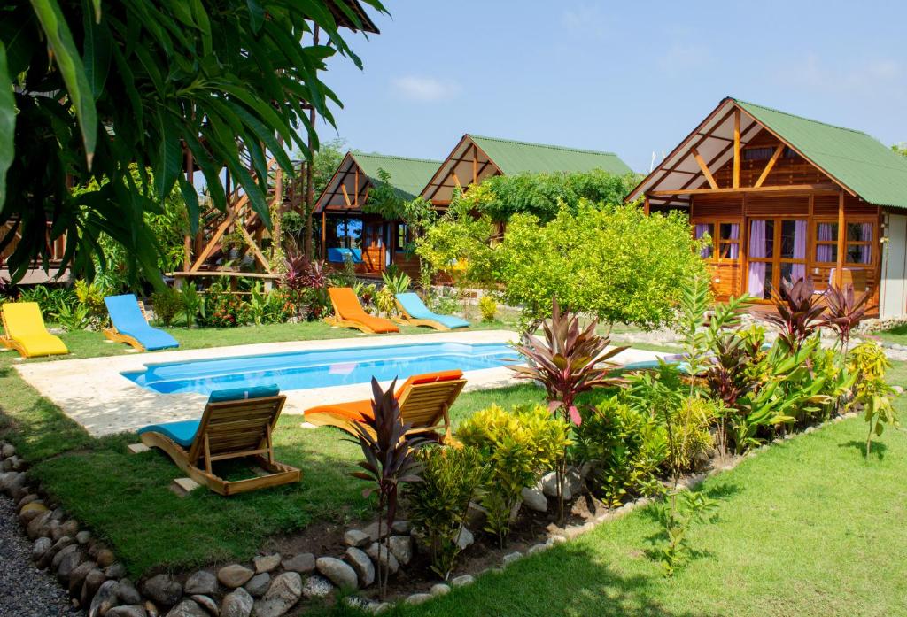 a resort with a pool and chairs in the yard at Nubá Boutique Hostel Palomino in Palomino