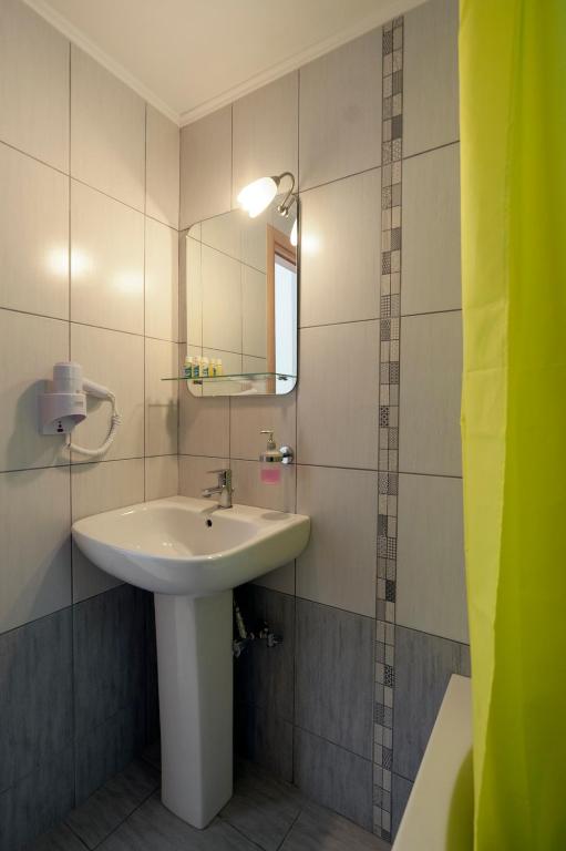 łazienka z umywalką i lustrem w obiekcie Spela House w mieście Áyioi Apóstoloi