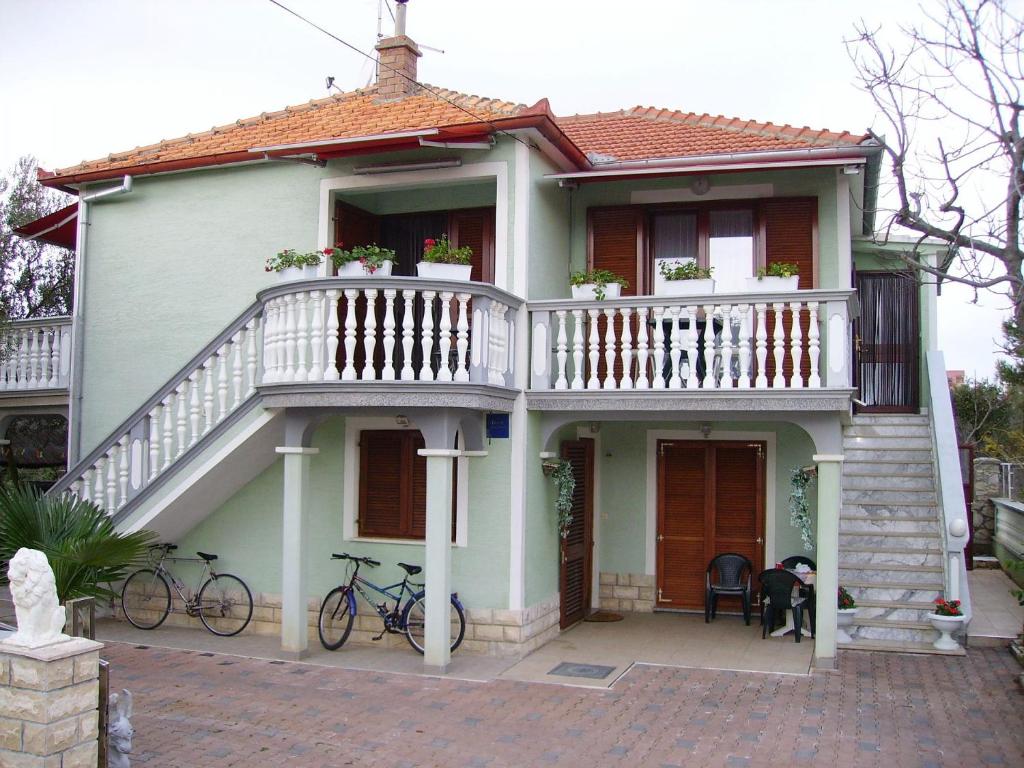 ein weißes Haus mit einem Balkon und zwei Fahrrädern in der Unterkunft Apartment Mare - with terrace in Pakoštane