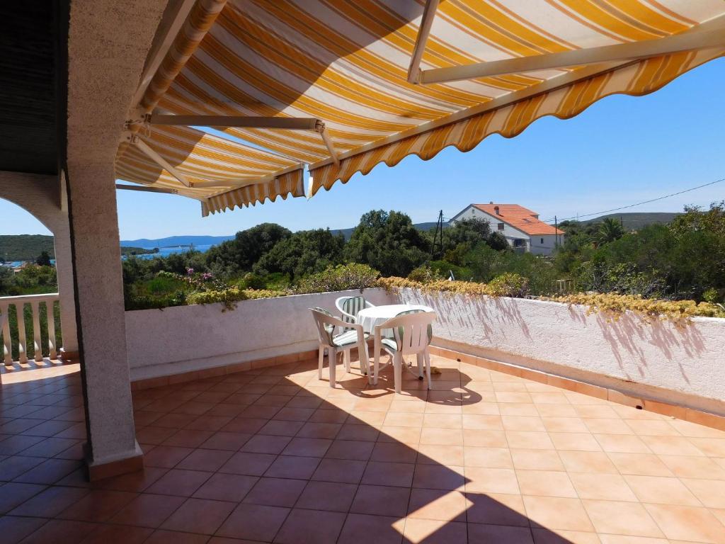 eine Terrasse mit einem Tisch und Stühlen auf dem Balkon in der Unterkunft Apartments Lado - 230 m from sea in Donje Selo