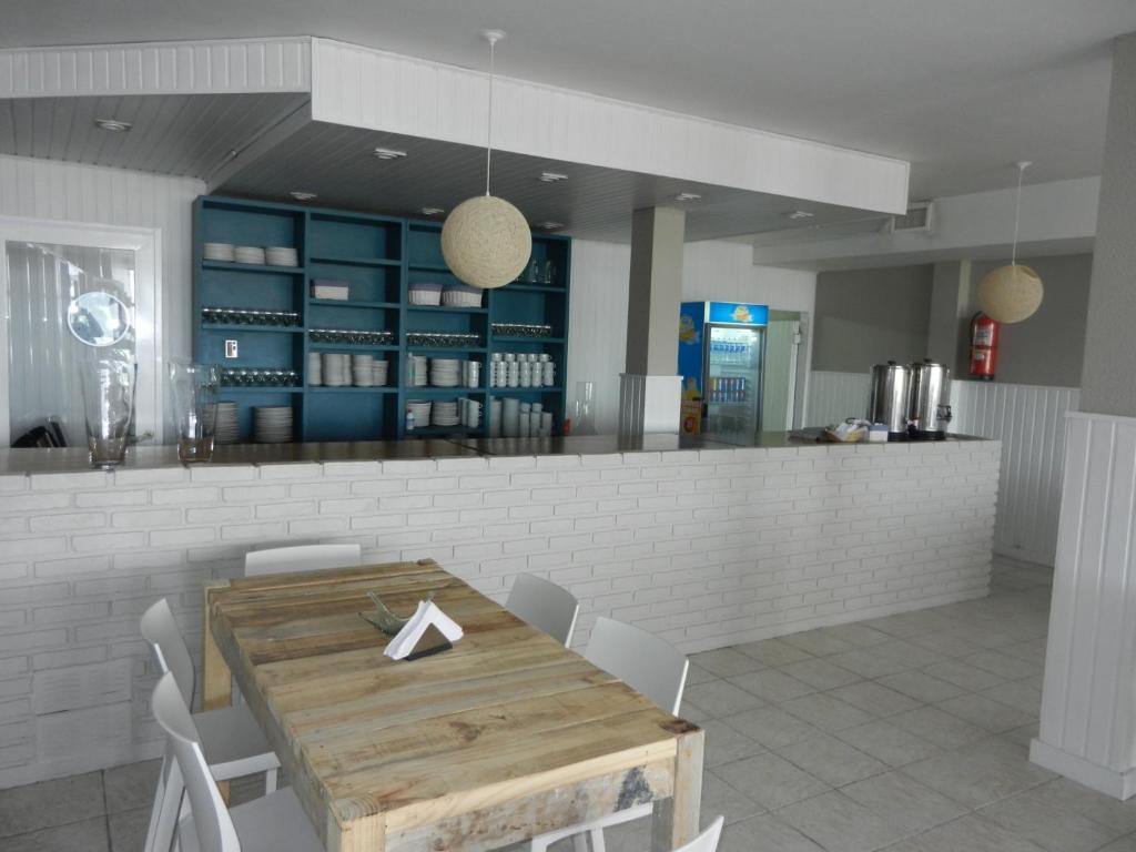 - une salle à manger avec une table et des chaises en bois dans l'établissement Hostal del Rey, à Puerto Madryn