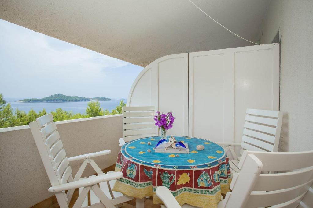 uma mesa e cadeiras numa varanda com vista para a água em Apartment Ante-50m from beach em Smokvica