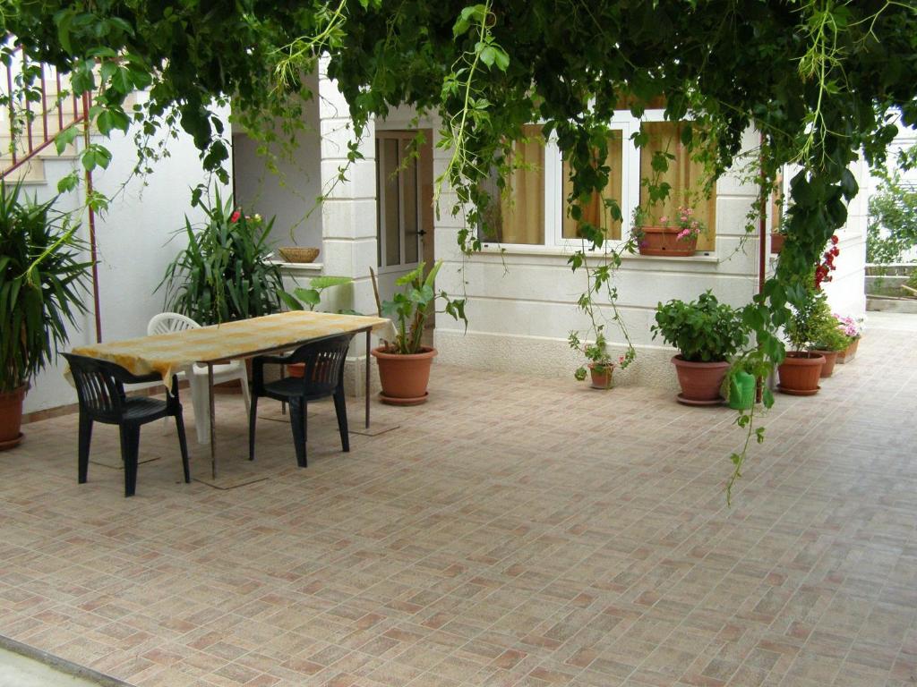 a table and chairs in a courtyard with potted plants at Apartments Marija - free parking in Hvar
