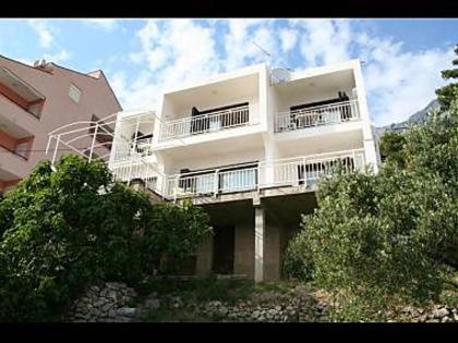 - un immeuble d'appartements blanc avec balcon et arbres dans l'établissement Apartments Vedra- free parking and close to the beach, à Baška Voda