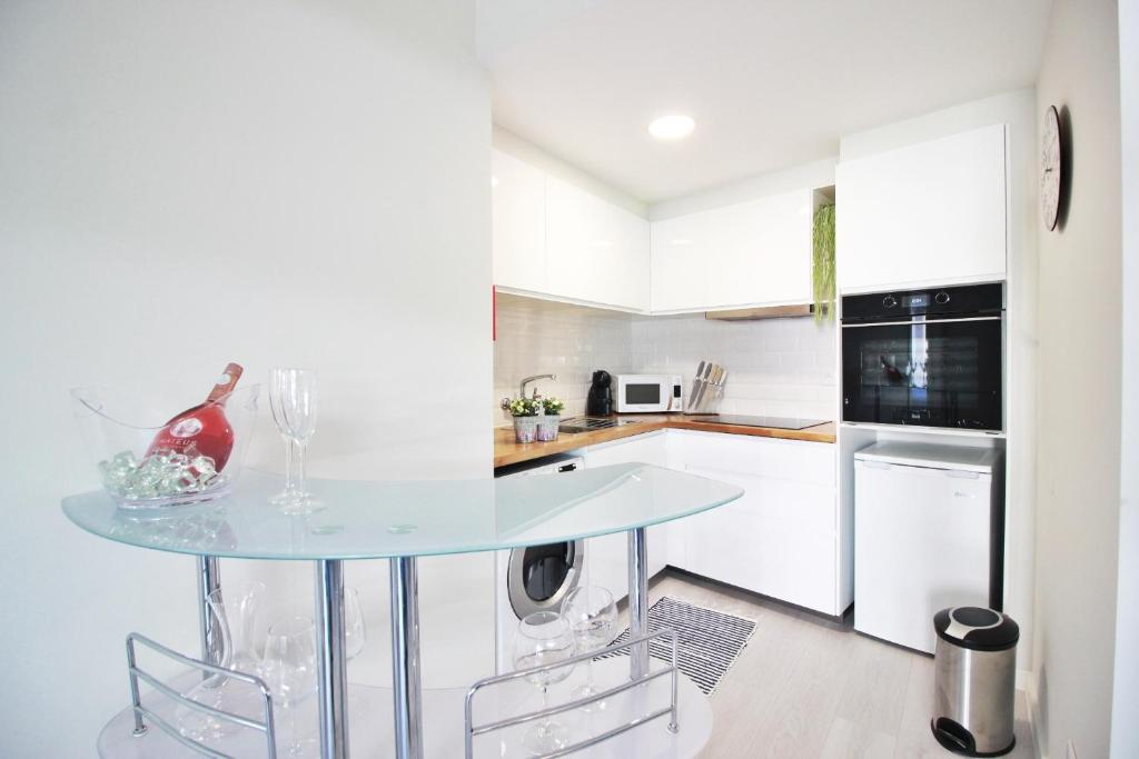 a kitchen with a glass table and a dishwasher at T1 Casino Estoril in Estoril