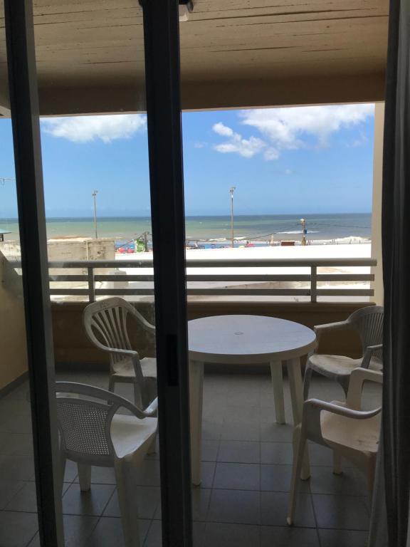 a table and chairs on a balcony with a view of the beach at Departamento Libra XX Frente al mar! Promos primavera! in Villa Gesell