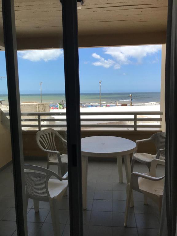 - Balcón con mesa y sillas y vistas a la playa en el Departamento Libra XX ¡Ante el mar!  Super promo findas!!  en Villa Gesell