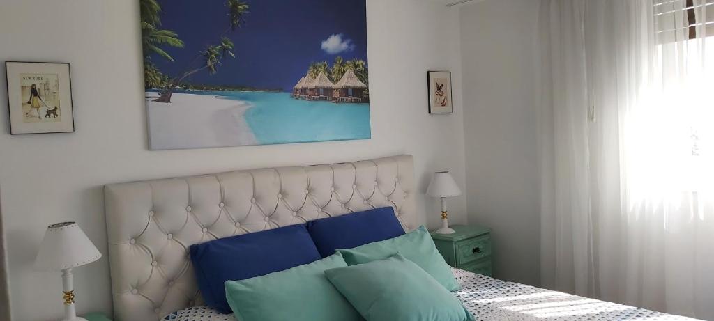 1 dormitorio con 1 cama con almohadas azules y verdes en High Recoleta View Apartment Seguridad 24hs en Buenos Aires