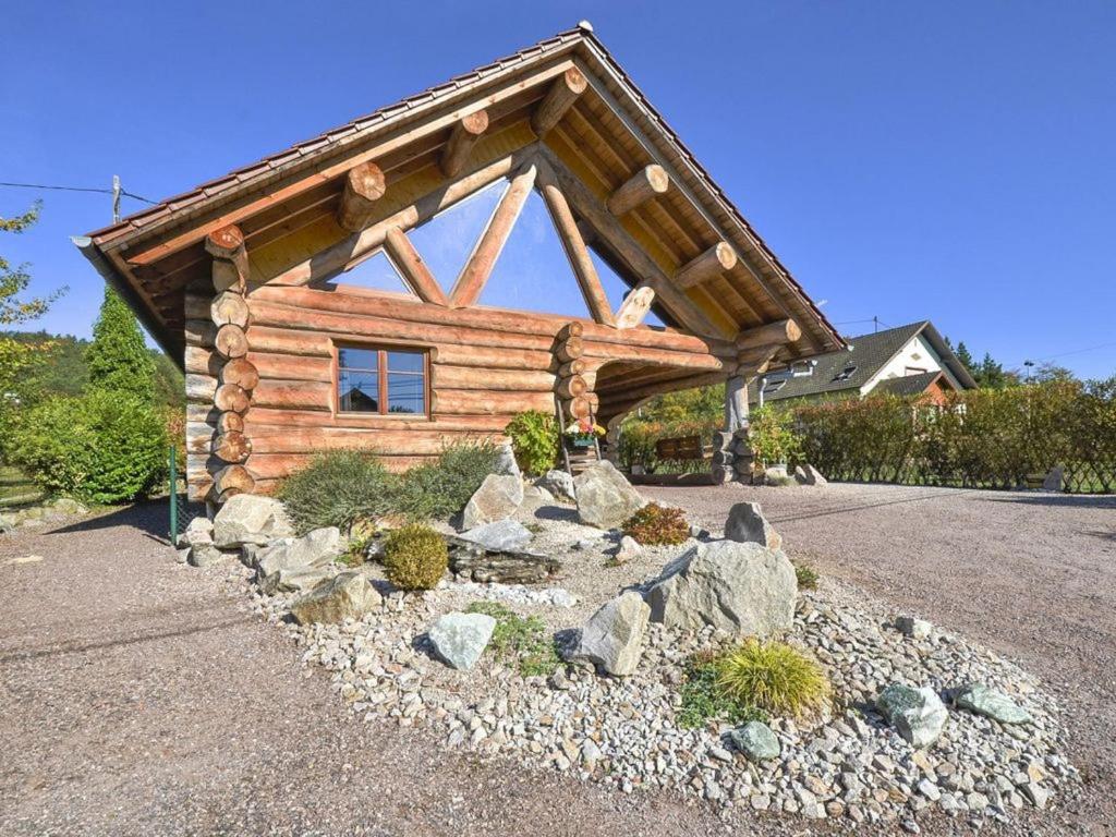 ein Blockhaus mit Felsen davor in der Unterkunft Le Chalet de Lyne in Erckartswiller