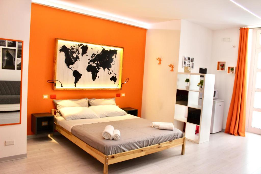una camera con un grande letto con una parete arancione di Ragusa 2 a Ragusa