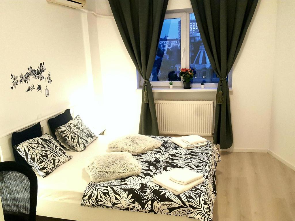 uma cama num quarto com uma janela em Diamond Apartments em Bucareste