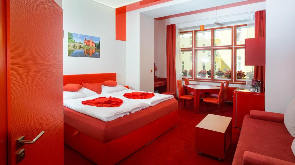 a red bedroom with a bed and a dining room at Apartment COLOURS - your 7 colour experience in centre of Prague in Prague