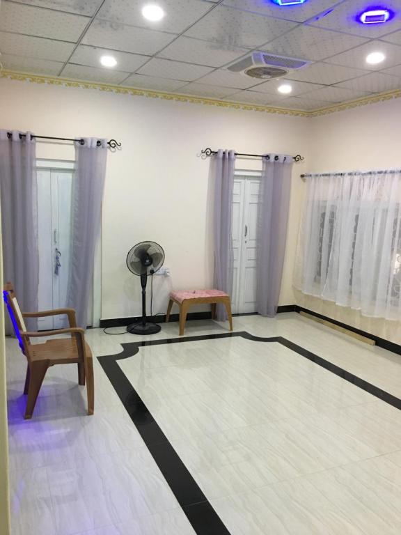 Cette chambre dispose d'une piste de danse avec une chaise et un ventilateur. dans l'établissement Uthayam, à Point Pedro