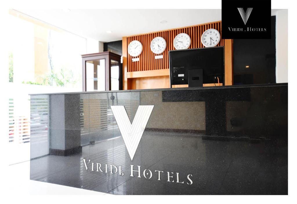 a counter with clocks on the wall in a room at Viridi Hotels Islamabad in Islamabad